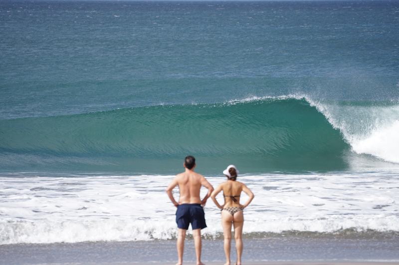 Couple watching a barreling wave