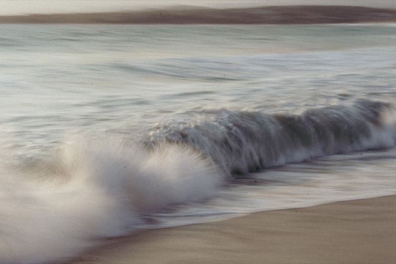 Long-exposure shot of a wave breaking on the shore